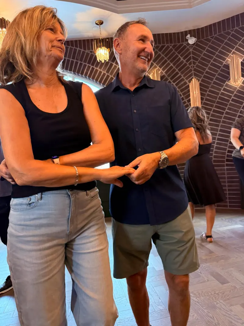 A couple in the cuddle position at a Chilliwack salsa class — the follow wrapped in front of the lead with both hands still joined