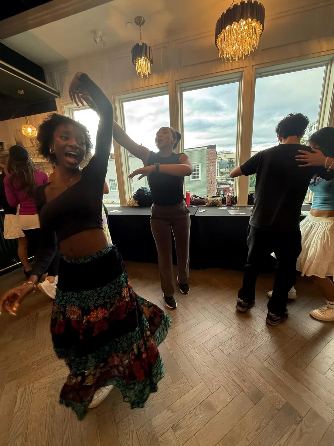 A dancer mid-spin with an arm raised, grinning, during open social dancing