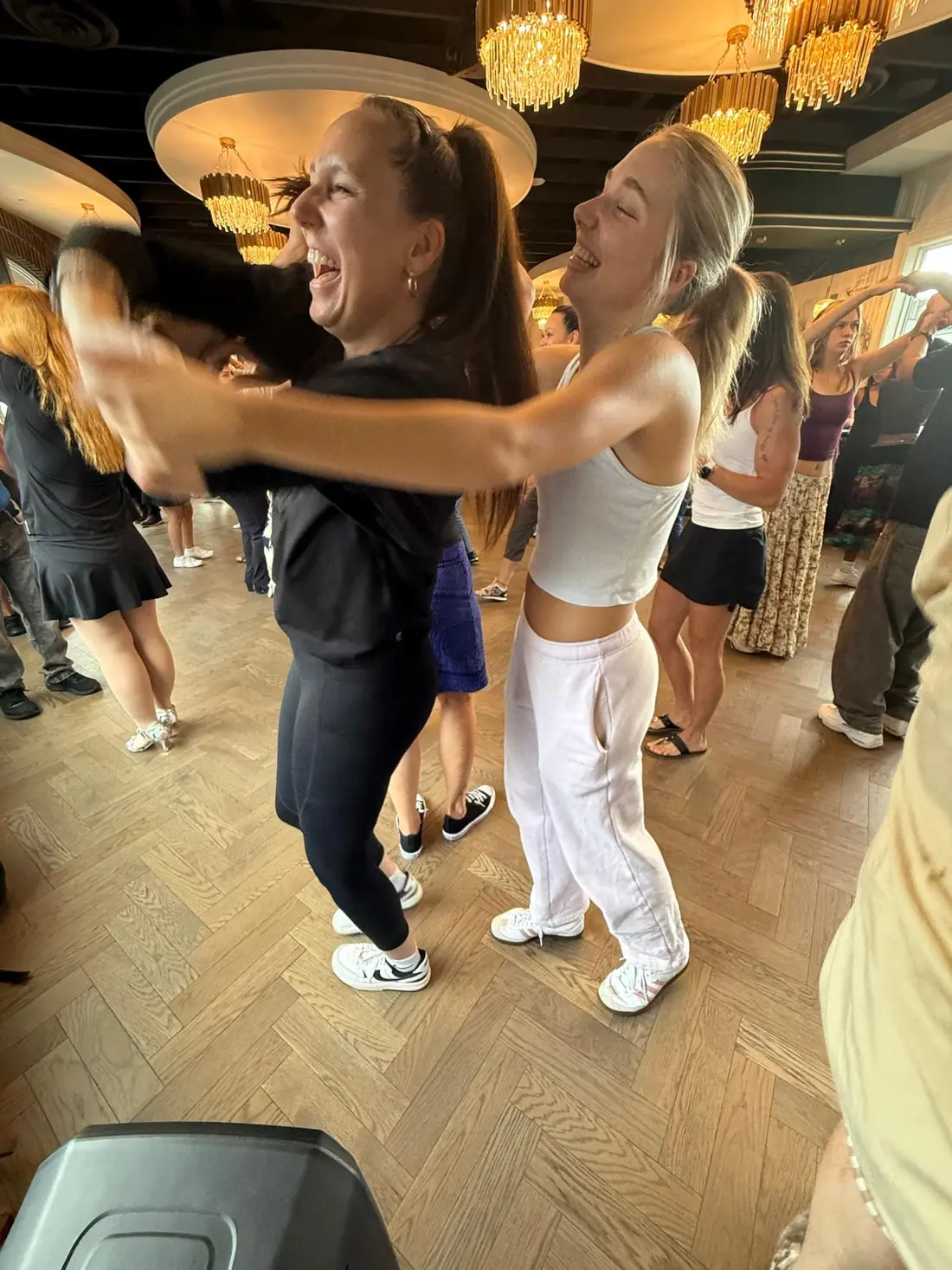 A couple dancing with the packed room behind them