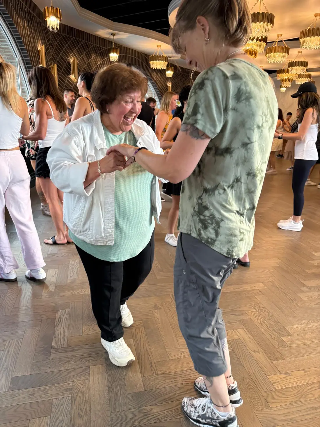 Dancers laughing together, arms raised, during the social dancing