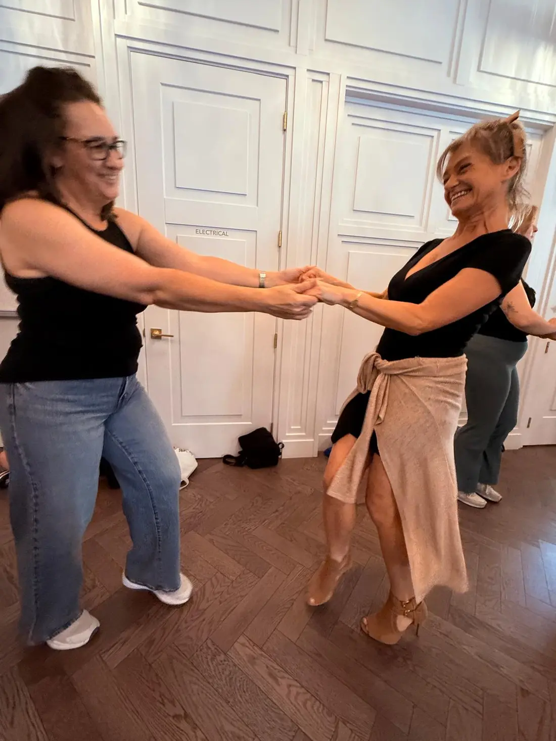 A pair mid-turn on the dance floor with the room full behind them