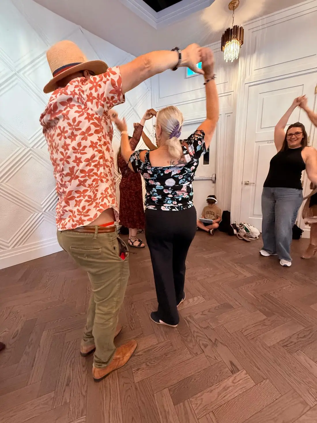 Two dancers working a turn together near the windows