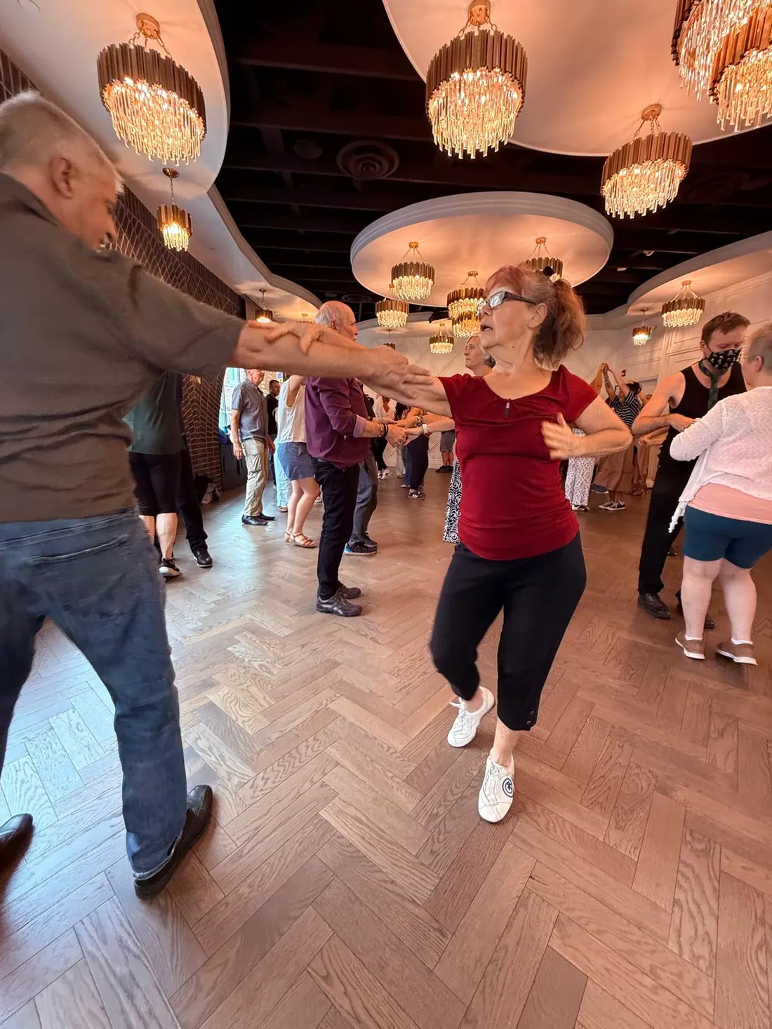 Two friends laughing mid-dance, hands joined
