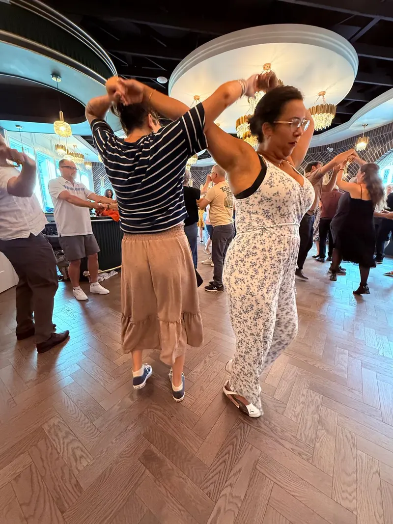 Two dancers with arms raised overhead mid-sombrero at a Chilliwack salsa night