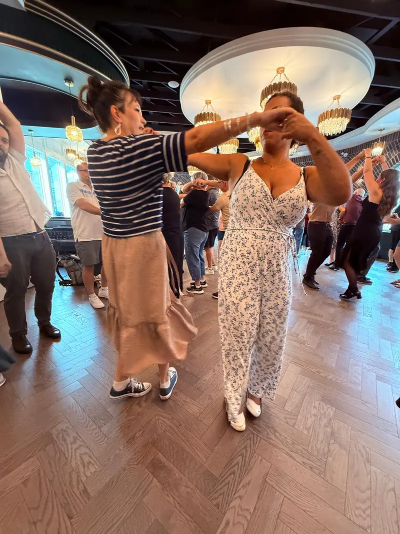 A pair working through the sombrero arm shape under the chandeliers at The Grand Hall